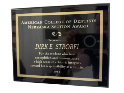 American College of Dentists Nebraska Section Award plaque presented to Dirk E. Strobel in 1984 for the student who best exemplified and demonstrated a high sense of ethics and integrity toward his responsibility as a dentist.