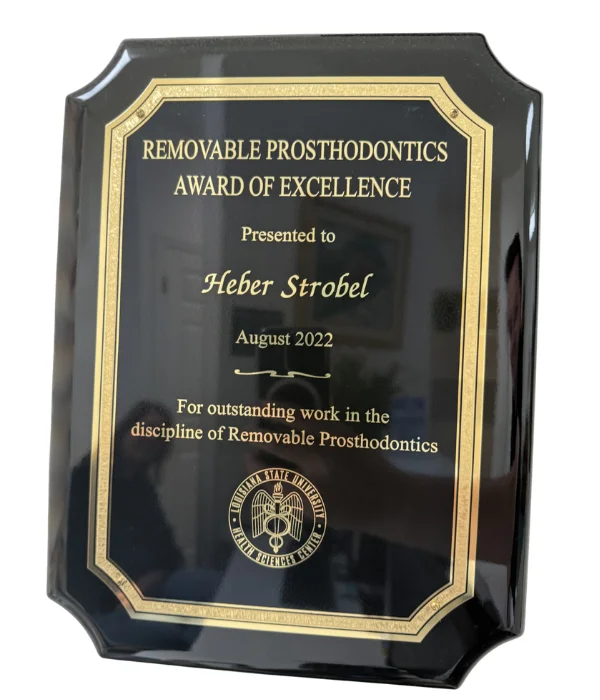 Removable Prosthodontics Award of Excellence plaque presented to Heber Strobel by the Louisiana State University Health Sciences Center School of Dentistry in August 2022 for outstanding work in the discipline of removable prosthodontics. Caption: Removable Prosthodontics Award of Excellence, LSU Health Sciences Center School of Dentistry, August 2022.