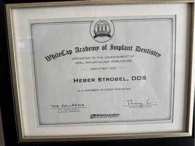WhiteCap Academy of Implant Dentistry certificate identifying Heber Strobel, DDS as a member in good standing, signed by clinical director P.K. Clark, D.M.D. and Riley Clark, D.M.D. Caption: Member in good standing, WhiteCap Academy of Implant Dentistry.